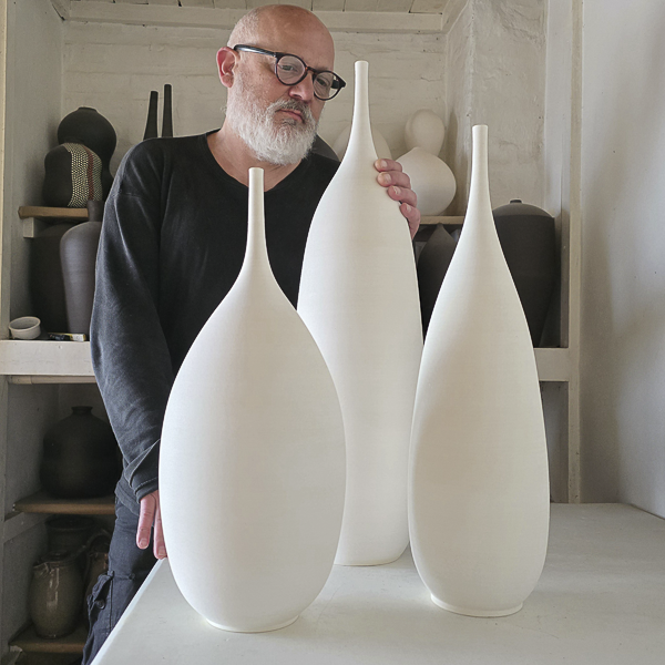 Jarrones de cerámica grandes en interior decorado con luz natural, piezas artísticas únicas.