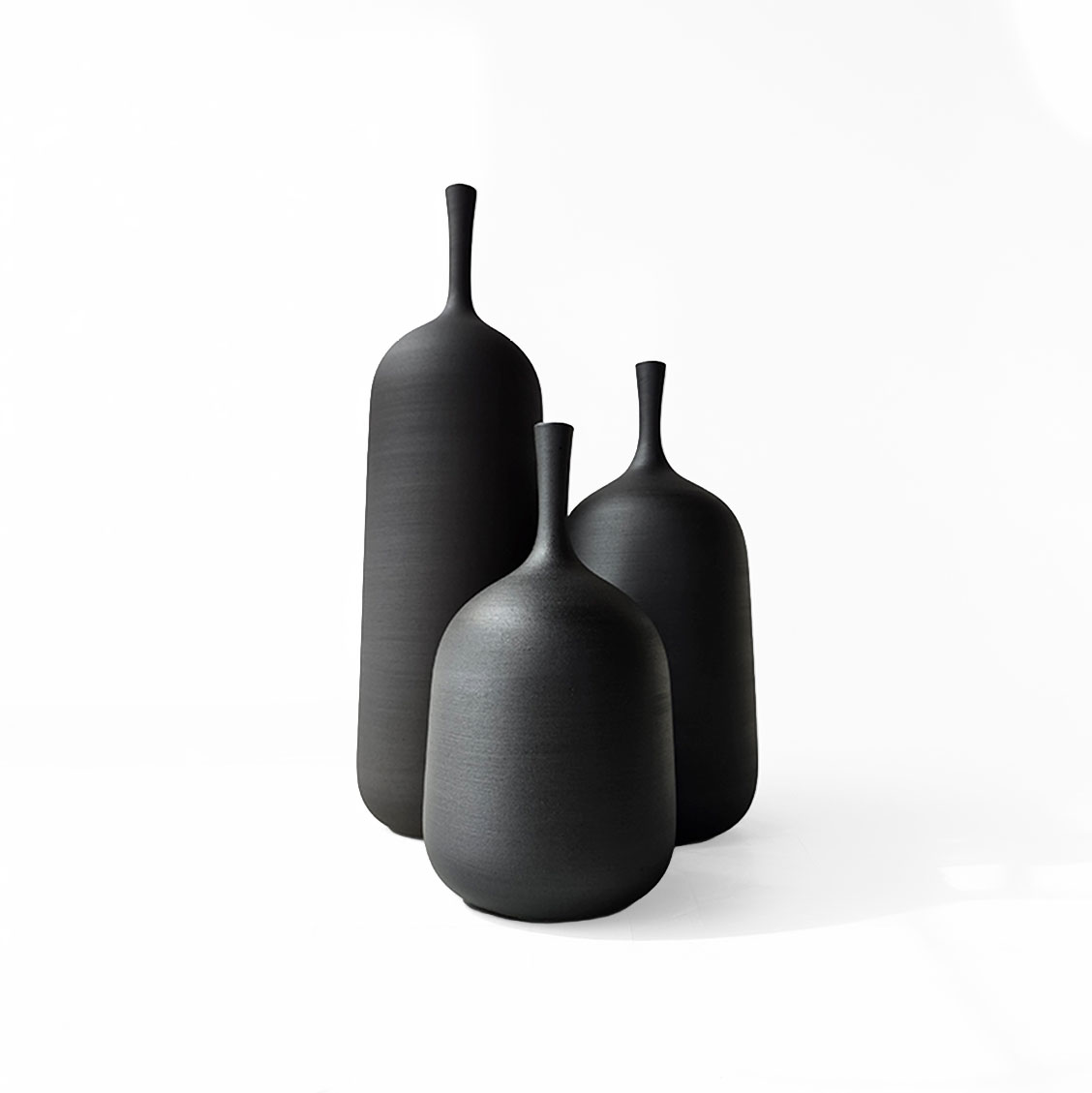 Dónde comprar jarrones decorativos de diseño: trío de gres negro Unikas Black con siluetas cilíndricas y cuellos delgados.